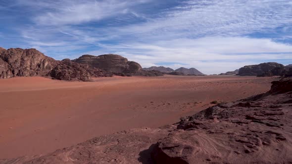 A Timelapse of Wadi Rum Desert Plain with Cars Driving Back and Forth