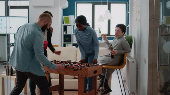 Diverse Team of Coworkers Enjoying Game at Foosball Table
