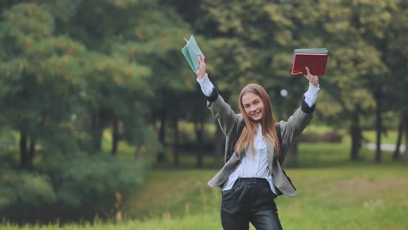 A Cheerful Student with Books in the Park in the Summer