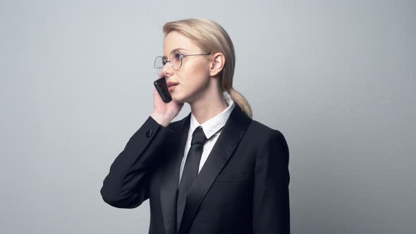 businesswoman in a classic business suit talking on mobile phone