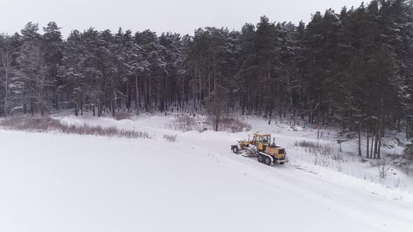 Aerial view of Snowblower Grader Clears Snow Covered Road next to the forest 11