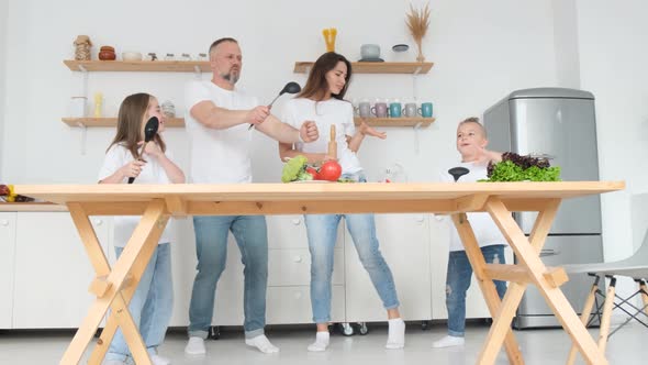 Artistic Family Dancing and Singing a Song in the Kitchen Happy Family Have Fun in the Kitchen