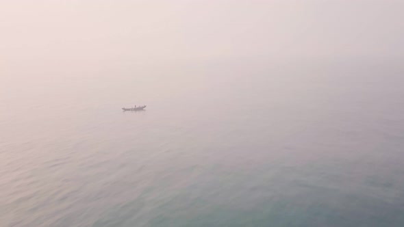 Fishing boat at sea at sunrise, net fishing. Aerial drone view