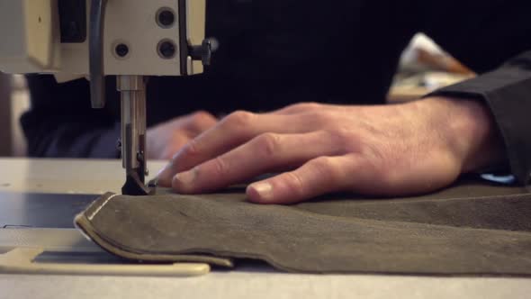 Crop hands sewing on machine