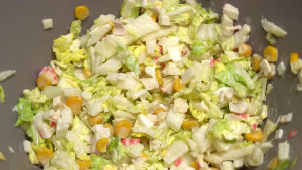 A vegetarian salad rotates in a circle in a salad bowl.