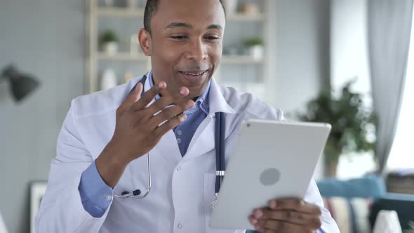 Online Video Chat on Tablet By AfricanAmerican Doctor