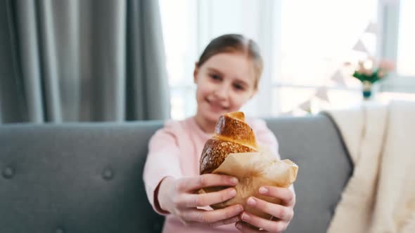 Little Girl Holding Croissant