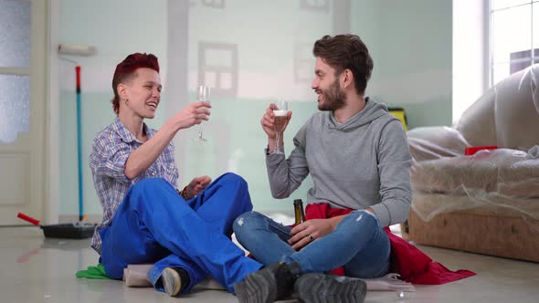 Wide Shot Happy Couple Toasting Drinking Champagne Talking Sitting on Floor in New House