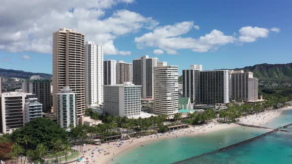 Aerial rising and panning wide shot of picturesque Waikiki Beach on the island of O'ahu, Hawaii. 4K