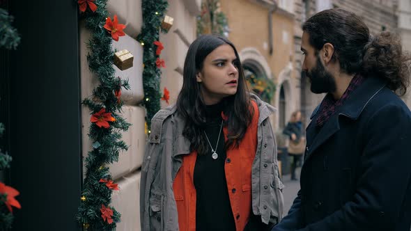 Romantic young couple in piazza Navona observing lighting carousel- back view