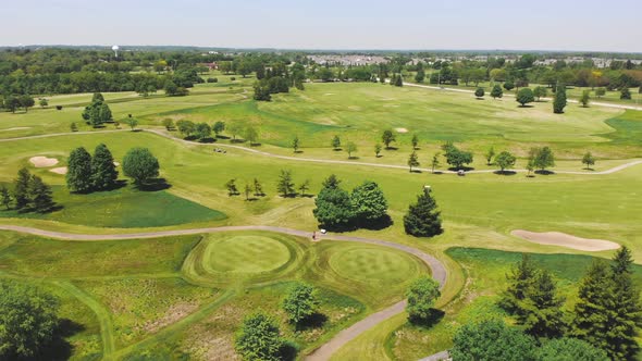 Aerial View From the Top n of the Golf Course, People and Cars on a Golf Course From a Height