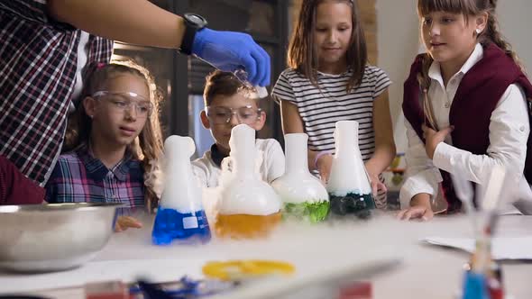 Asian Science Teacher Making an Experiment for Six School Children by Putting Dry Ice