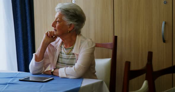 Thoughtful senior woman sitting at table 4k