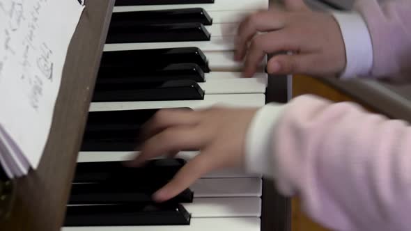 Child playing piano. Close up