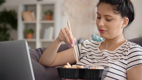 Handheld video of Asian woman eating during video call