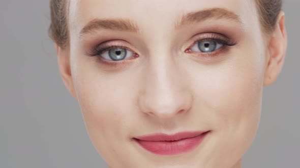 Studio portrait of young, beautiful and natural woman over grey background.