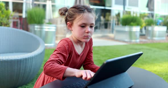 A young girl attempts to learn remotely on her laptop over distance learning due to the COVID-19 Cor