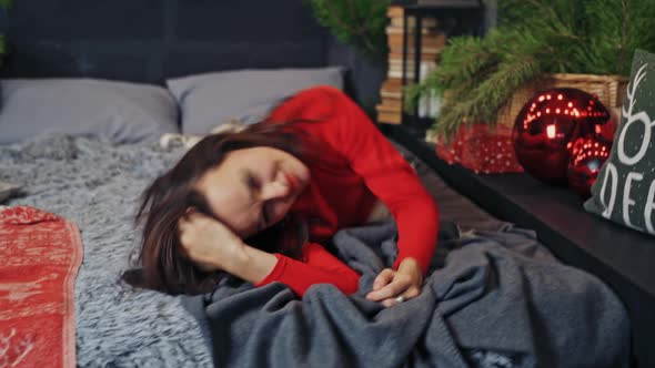 Cute brunette laying and posing on bed before winter holidays. 