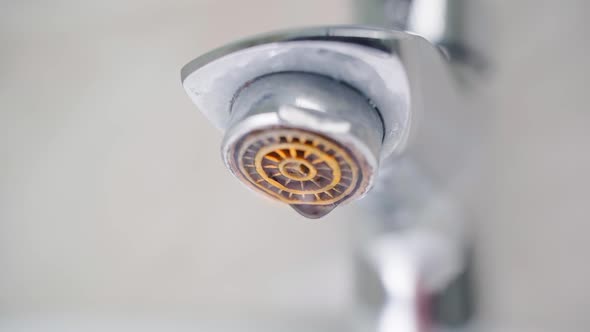 Drops of Water Falling From a Rusty Faucet Closeup