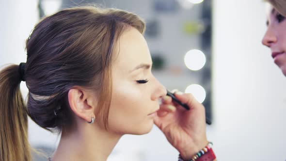 Closeup View of Makeup Artist Applying Eyeshadow on Eyelid Using Makeup Brush