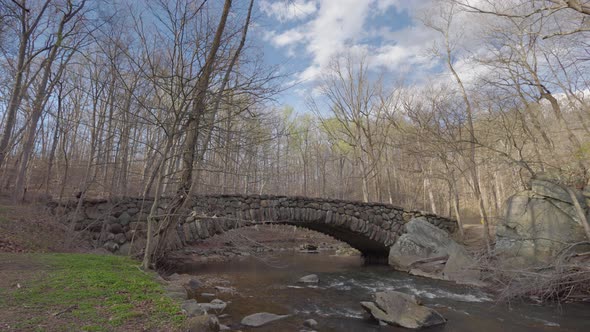 Bicyclists Cross Boulder Bridge In Rock Creek Park - Washington, D.C. - Early Spring - Wide Shot