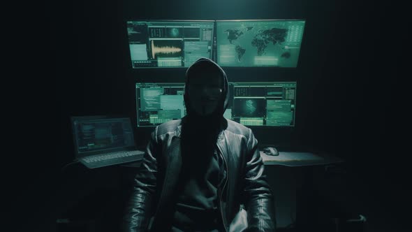 Unrecognizable Cyber Criminal Sitting Near Computers