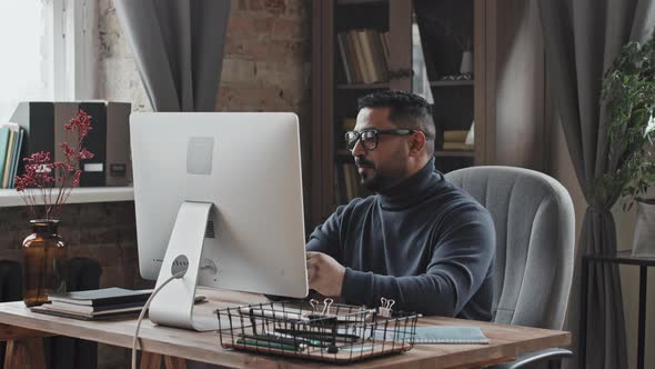 Middle Eastern Man Discussing Business on Video Call on Computer