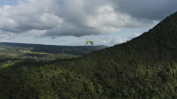 Aerial view of a person doing paragliding among the mountain, Mauritius.