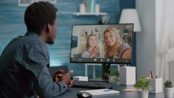 Selective Focus on African American Man Talking with Friends and Family Using Online Video Call