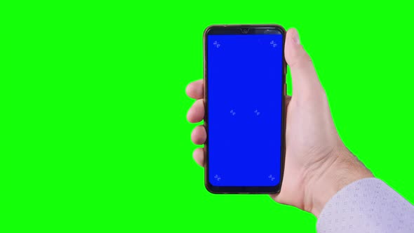Male Hand Holding Smartphone with Blue Screen with Markers on Green Background