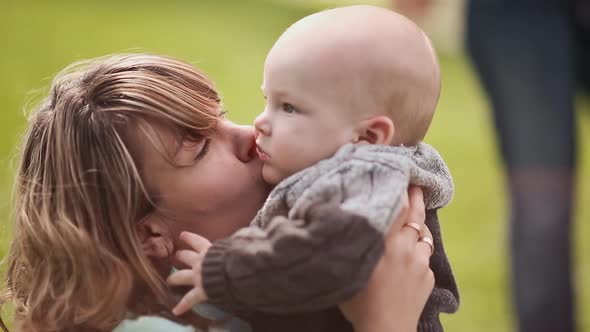 Beautiful Mother and Baby on a Green Lawn