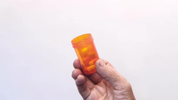 Top View of Senior Women Holding Pill Container on White Background 