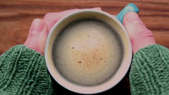 A Men's Hands Are Holding a Cup of Aromatic Coffee