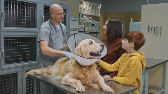 Portrait Of Veterinarian With Dog And Its Owners