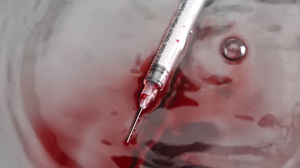 White Syringe with Blood Falls on the White Floor