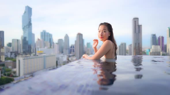 Young asian woman enjoy around outdoor swimming pool for leisure