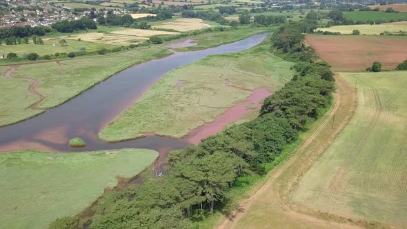 4K Aerial pan, River Otter and agricultural pastures by a coastal town in Devon, England