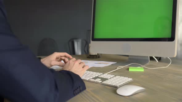 male hands typing on a keyboard with a view on the monitor with chroma key