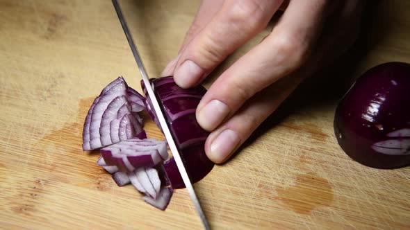 autentic woman's hands is cutting italian red Tropea onions