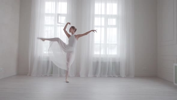 Young Woman Dancing Classical Ballet in a Bright Hall