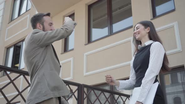 Cute Young Woman and Confident Man in Formal Wear High Five Together on the Terrace. Business