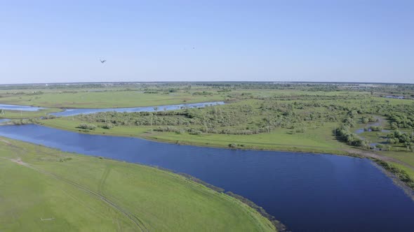 Scenic Aerial View of a River and Green Fields in a Countryside