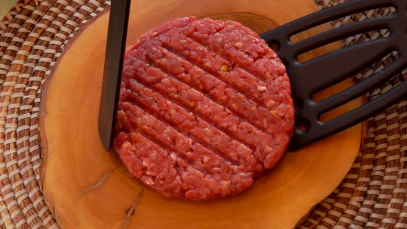 Cook Raises Cutlet for Hamburgers with Two Spatula