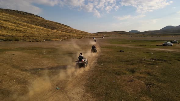 Aerial View From Behind ATVs by Lake and Mountain