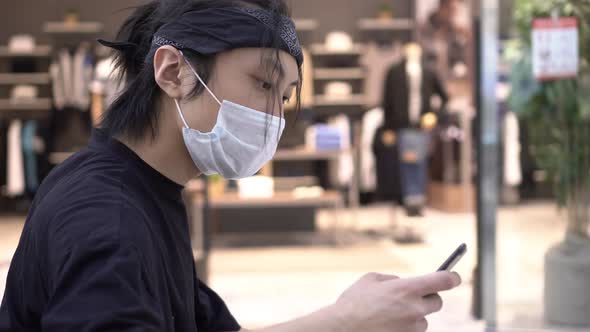 Asian Man in a Medical Mask at the Mall