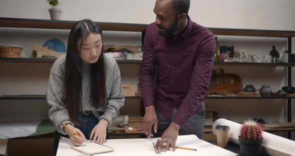 Female Engineer and Black Man Doing Sketch or Plan