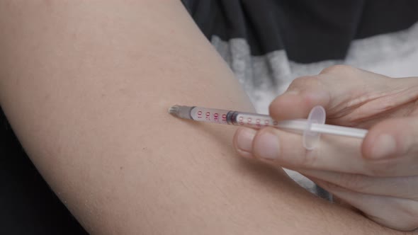 Closeup Shot of Covid19 Coronavirus Vaccine. Injection with an Insulin Syringe. Carrying Out