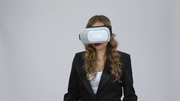 Woman with Virtual Reality Goggles on Gray Background