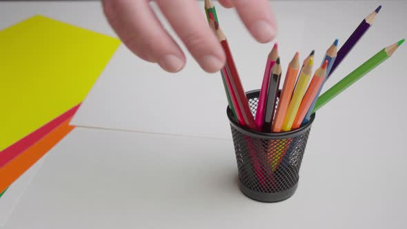 Closeup Hand Takes a Black Pencil From a Set of Pencils