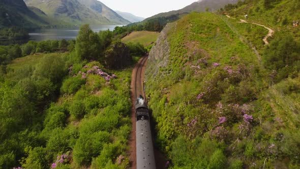 Scotland Steam Train Drone Following Shot Reveal of Converging Mountains in Distance